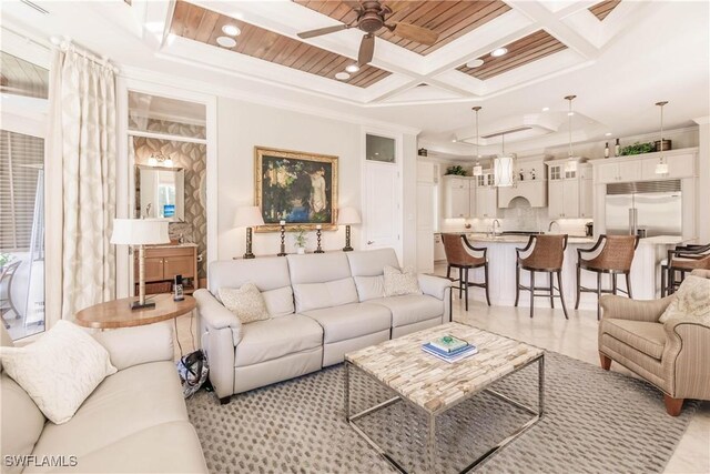 living room featuring beamed ceiling, crown molding, coffered ceiling, and ceiling fan