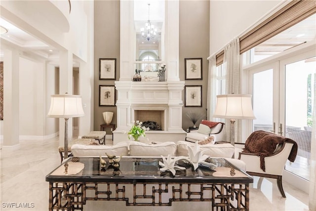 sitting room with a high ceiling, a notable chandelier, a fireplace, and french doors