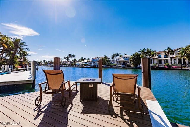 view of dock featuring a water view and an outdoor fire pit