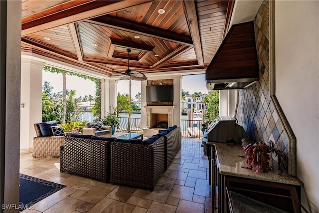 exterior space with exterior fireplace, a tray ceiling, and wooden ceiling