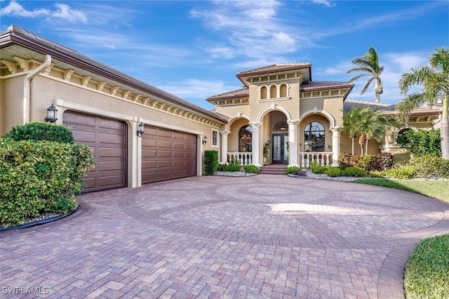 mediterranean / spanish home with covered porch and a garage