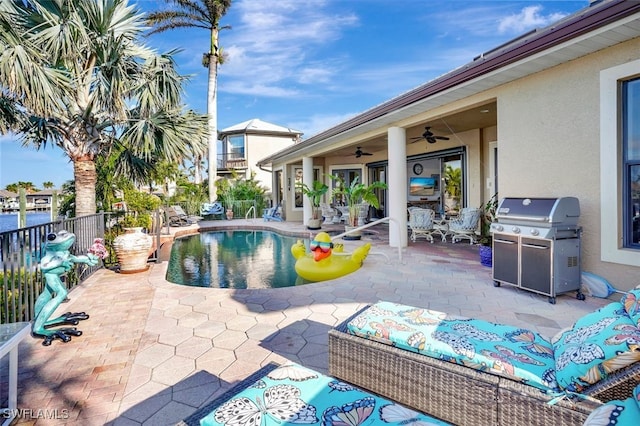 view of pool with ceiling fan, a patio area, and grilling area