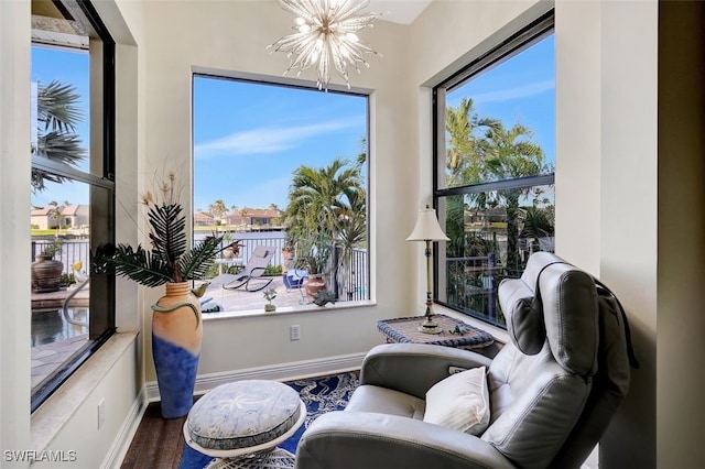 sitting room featuring a chandelier, a wealth of natural light, and wood-type flooring