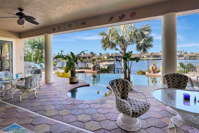 view of patio with ceiling fan, a water view, and a fenced in pool