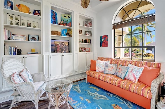 sitting room with built in shelves and hardwood / wood-style flooring