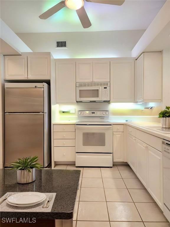 kitchen with white appliances, sink, ceiling fan, light tile patterned floors, and white cabinetry