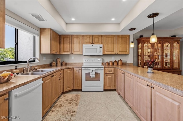 kitchen with pendant lighting, a raised ceiling, white appliances, and sink