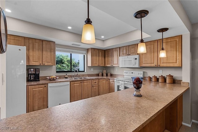 kitchen featuring pendant lighting, kitchen peninsula, white appliances, and sink