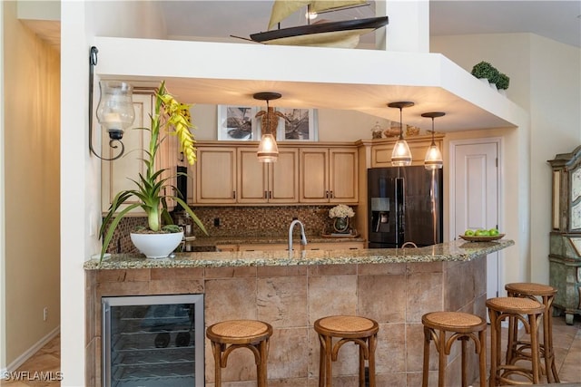 kitchen featuring refrigerator with ice dispenser, backsplash, decorative light fixtures, and wine cooler