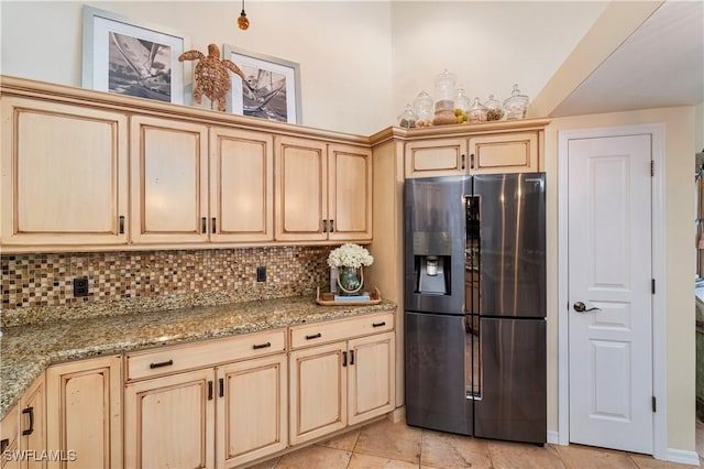 kitchen with light stone countertops, stainless steel fridge with ice dispenser, backsplash, and light brown cabinets