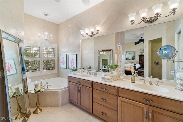 bathroom with tile patterned floors, tile walls, vanity, independent shower and bath, and ceiling fan with notable chandelier