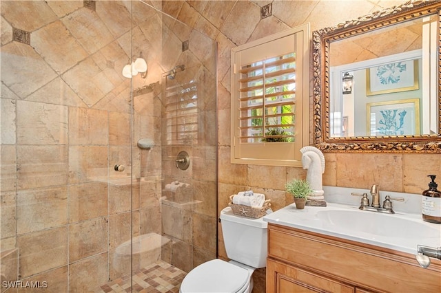 bathroom featuring vanity, toilet, an enclosed shower, and tile walls