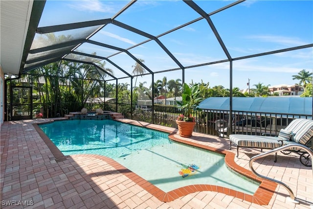 view of pool with glass enclosure and a patio