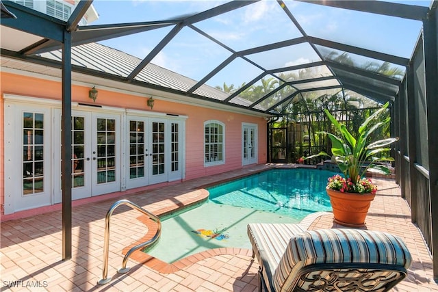 view of swimming pool with french doors, glass enclosure, and a patio area