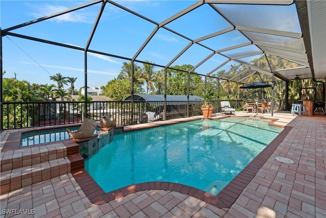 view of pool with glass enclosure and a patio area