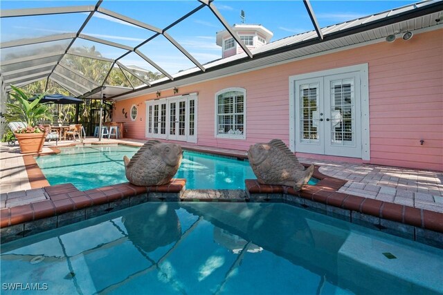 view of swimming pool with glass enclosure, a patio, and french doors