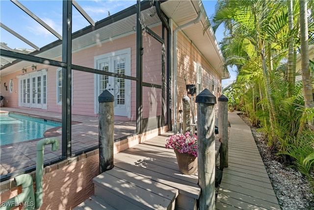 view of side of home featuring a lanai, a patio area, and french doors