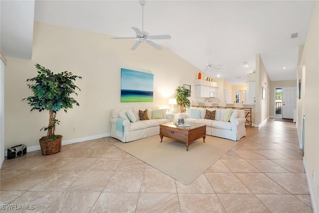 tiled living room with ceiling fan and high vaulted ceiling