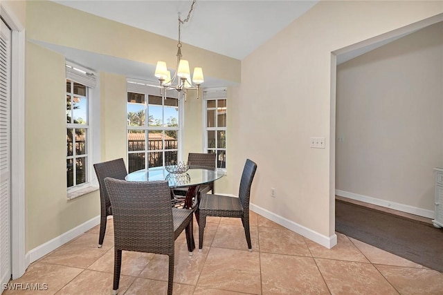 tiled dining room with an inviting chandelier