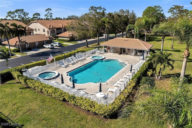 view of swimming pool featuring a lawn, a patio area, and a community hot tub