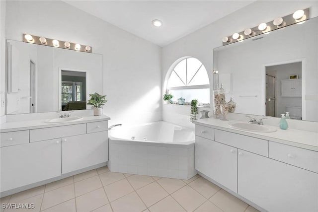 bathroom featuring tile patterned floors, vanity, and tiled tub