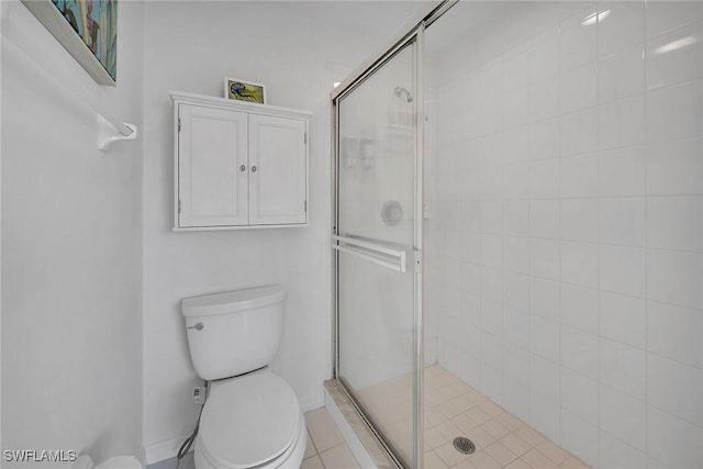 bathroom featuring tile patterned flooring, toilet, and an enclosed shower