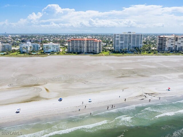 drone / aerial view featuring a water view and a view of the beach