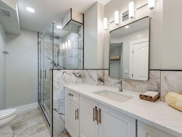 bathroom with vanity, toilet, and a shower with shower door