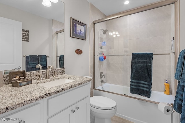 full bathroom featuring vanity, toilet, and bath / shower combo with glass door