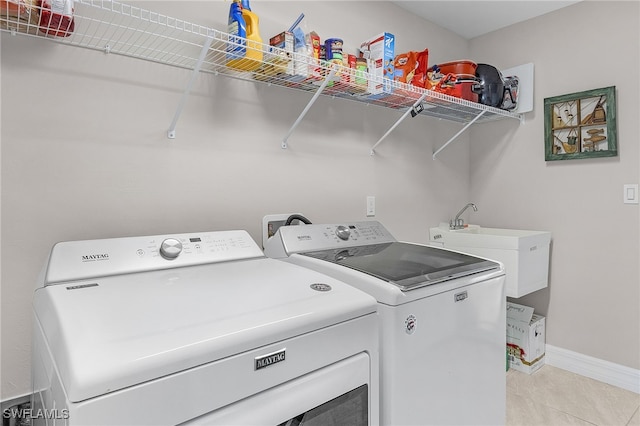 laundry area with washer and clothes dryer, light tile patterned flooring, and sink