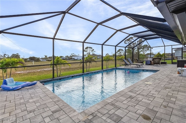 view of pool featuring glass enclosure and a patio area