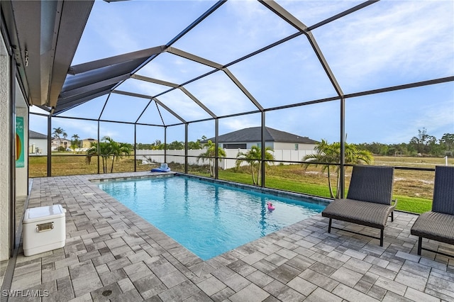 view of pool with glass enclosure and a patio area