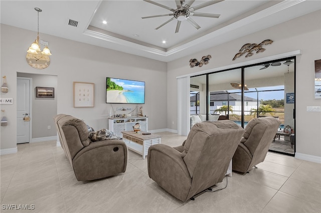 tiled living room featuring a raised ceiling and ceiling fan