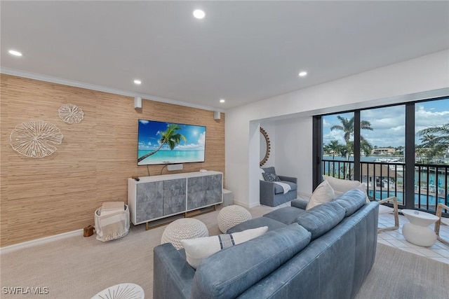 carpeted living room with wooden walls and crown molding