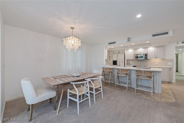 carpeted dining room featuring sink and an inviting chandelier