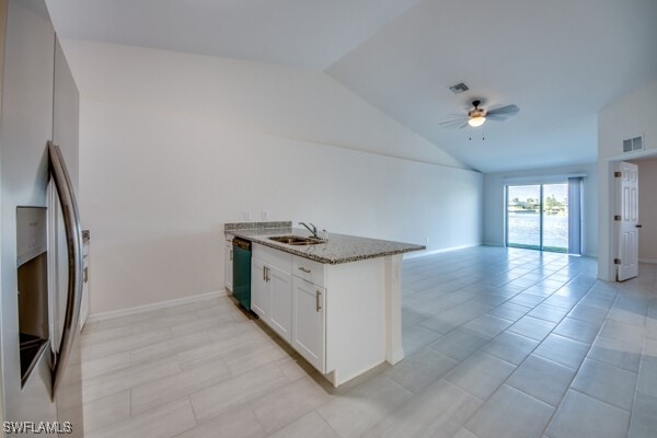 kitchen featuring white cabinets, sink, vaulted ceiling, ceiling fan, and stainless steel fridge