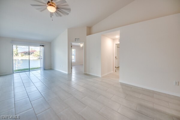 tiled spare room featuring ceiling fan and vaulted ceiling