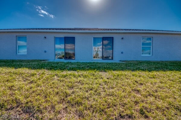 back of house featuring a lawn