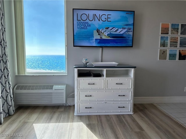 interior details with wood-type flooring and an AC wall unit