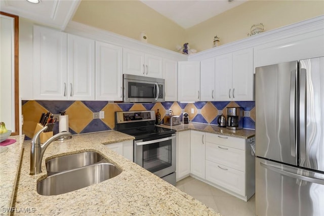 kitchen featuring sink, tasteful backsplash, light stone counters, white cabinetry, and stainless steel appliances