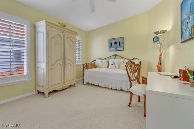 bedroom with light carpet, multiple windows, and ceiling fan