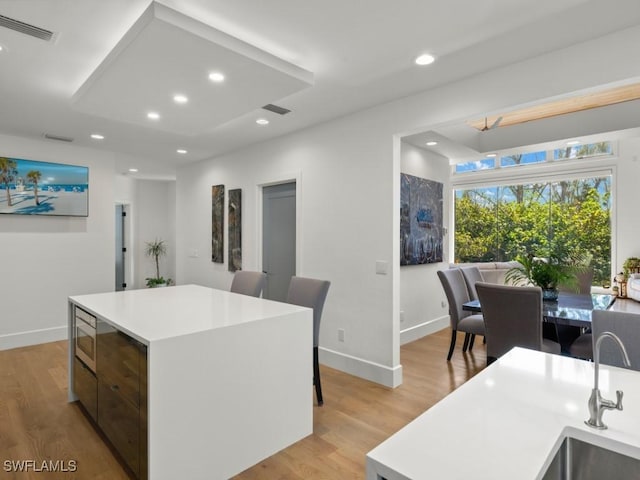 kitchen with a center island, sink, and light hardwood / wood-style flooring