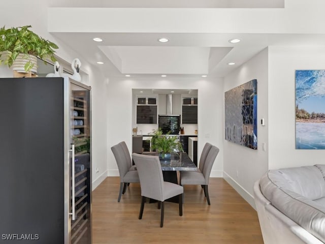 dining space featuring a tray ceiling and light hardwood / wood-style floors