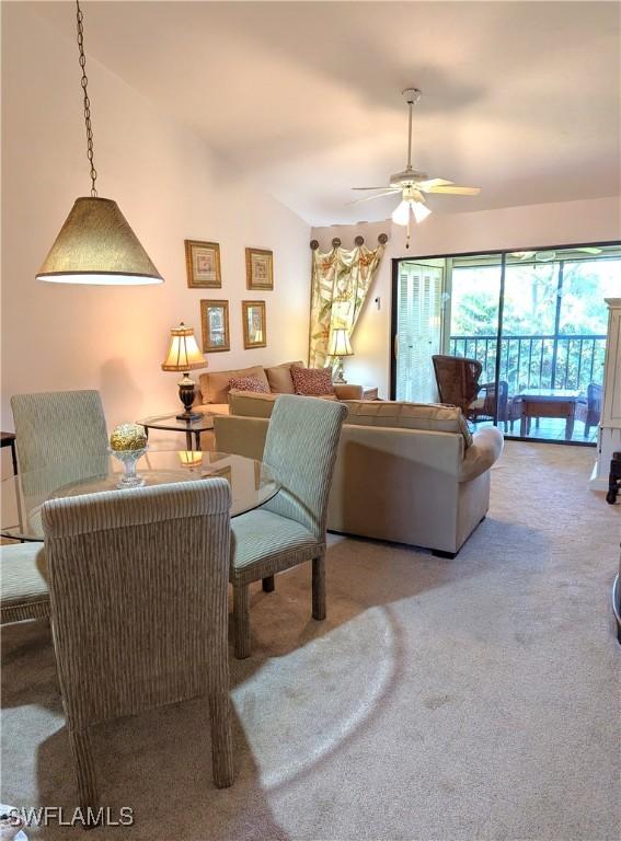 living room with carpet floors, vaulted ceiling, and ceiling fan