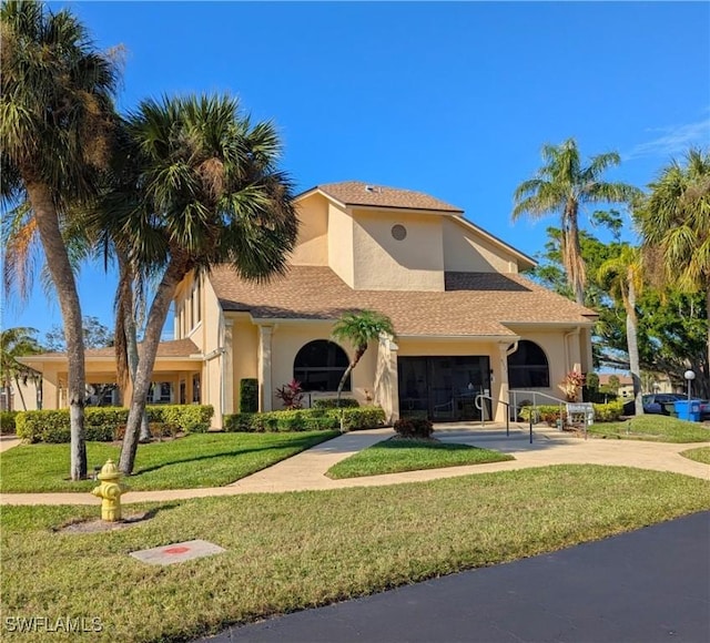 mediterranean / spanish-style home featuring a front yard and stucco siding