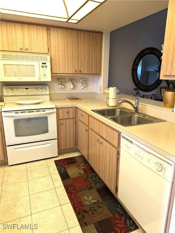 kitchen featuring light tile patterned floors, white appliances, and sink