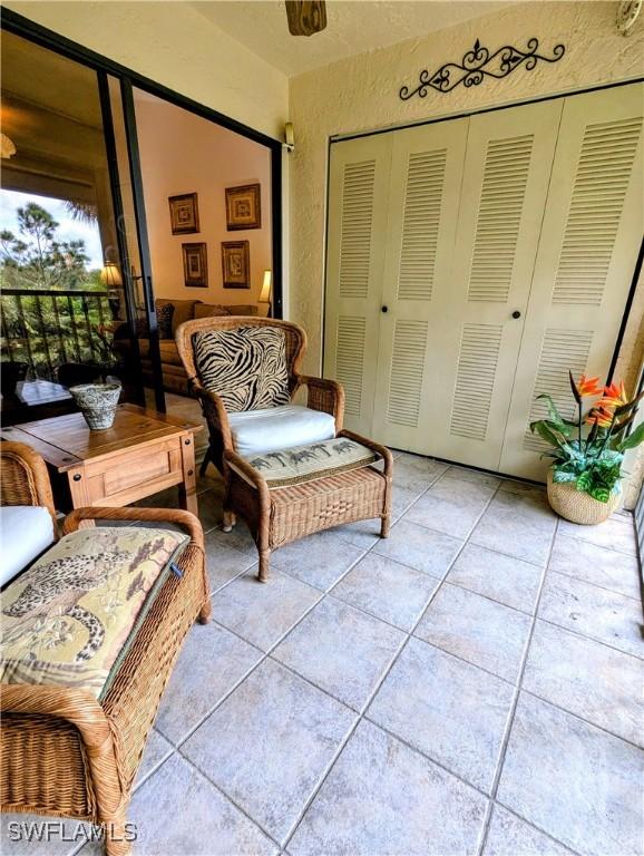 sitting room featuring light tile patterned floors and a textured wall