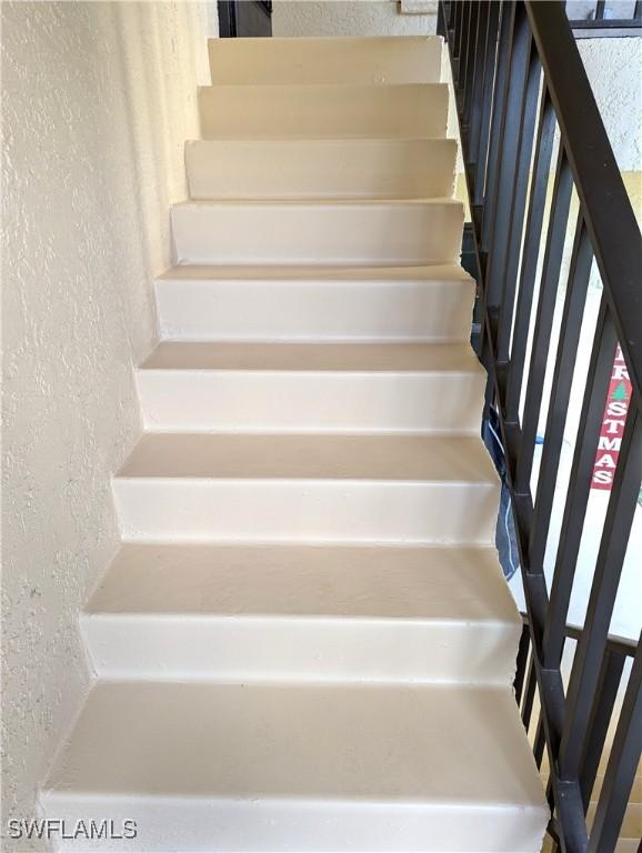 stairway featuring a textured wall