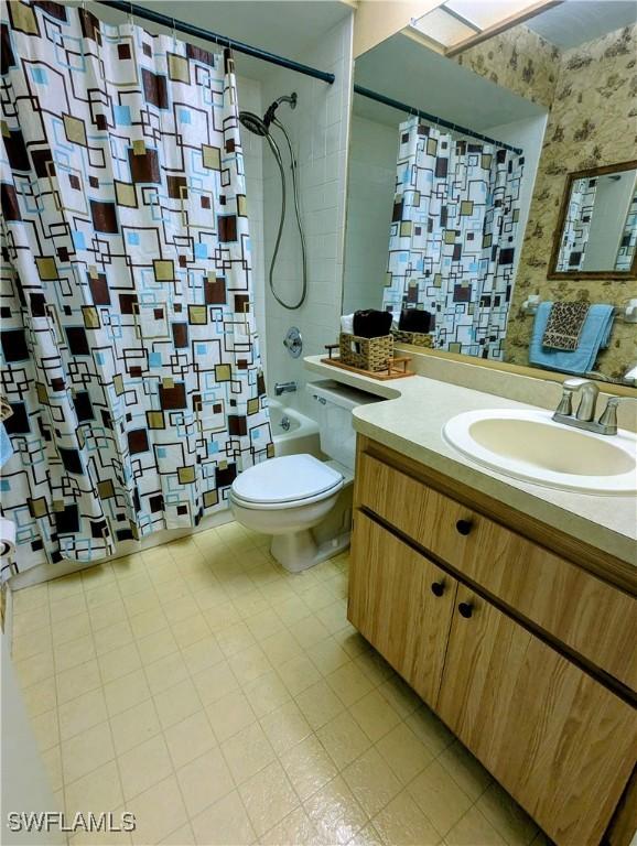 full bathroom featuring shower / bath combo, vanity, toilet, and wallpapered walls