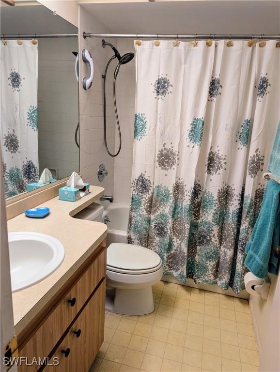 full bathroom with shower / bath combo with shower curtain, tile patterned flooring, vanity, and toilet